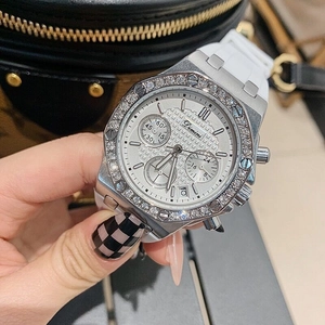 Detail of white silicone strap watch with diamond bezel against a quilted bag background