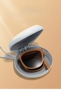 Foldable UV protection sunglasses in brown with a matching round blue zippered storage case