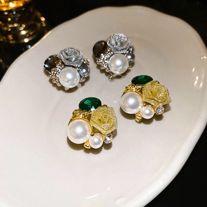 Vue détaillée de boucles d'oreilles rose avec perles et pierres sur plateau en céramique