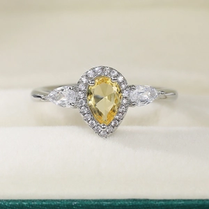Macro shot of yellow pear-cut zircon ring in a velvet jewelry gift box setting