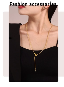 Close-up of golden snake head necklace and matching gem earrings on a fashion model