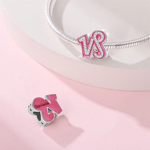 Macro view of pink enamel Capricorn charm with white zircon in silver-plated copper