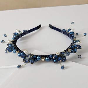 Detail of handmade deep blue crystal and pearl cluster beading on a silk-wrapped headband