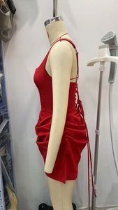 Détail de la robe moulante rouge avec laçage au dos et détails de fronces latérales