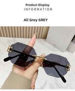Detail of grey rimless sunglasses with geometric cut edges and golden metal bridge