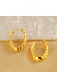 Detailed view of 18k gold plated multi-layer oval hoop earrings on elegant silk fabric