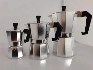 Three different sizes of silver aluminum Moka pots with ergonomic black handles on a white background