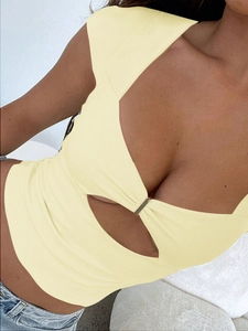 Detail view of the deep V-neckline with a metal ring and cut-out on a yellow knit top