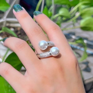 Détail de la bague ouverte argentée avec double perles et sertissage micro-pave de zircons