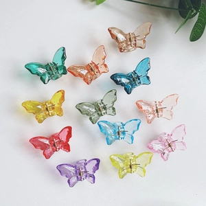 Top view of mini butterfly hair claws in various translucent candy colors on a clean background