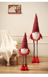 Detailed view of large and small Christmas gnomes on warm wood floor with festive decor