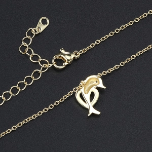 Golden dolphin necklace with zircon pendant on black background, elegant animal jewelry