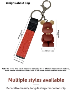 Macro detail of dark red bear keychain with embossed Advance bravely leather strap