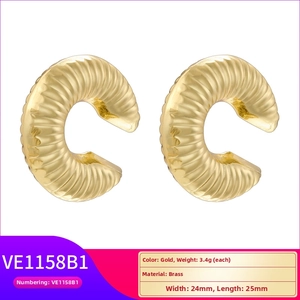 Macro shot of gold brass C-shaped hoop earrings with textured spiral ridges and dimensions