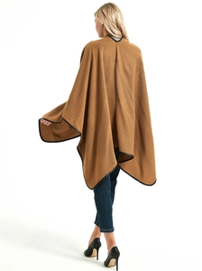 Rear view of brown knitted poncho with black leather piping and stylish slit hem detail