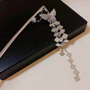 Detail of silver butterfly hair stick with long dangling square sequin tassels on black stand
