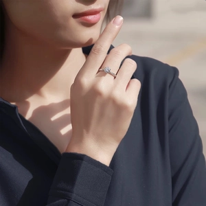 Close-up of elegant six-prong silver ring with sparkling round moissanite on model hand