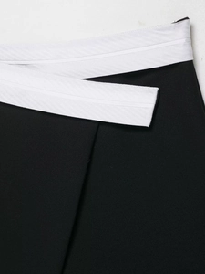 Close-up of contrast waist design and woven fabric texture on a two-piece suit
