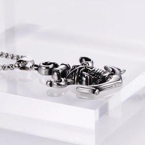 Side view detail of retro punk anchor and skull pendant with embossed textures