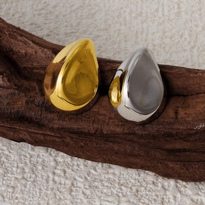 Artistic still life of gold and silver teardrop earrings on a vintage branch