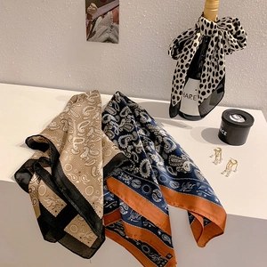 Variety of paisley and leopard silk scarves styled with elegant home accessories