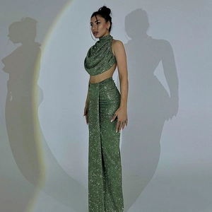 Sparkly green sequin two-piece set featuring a halter crop top and high-waisted maxi skirt
