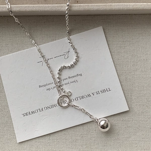 Detail of silver double layer necklace with spherical pendant and stylish OT clasp toggle