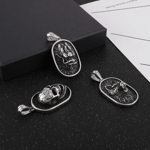 Detail view of retro titanium steel dragon, skull, and wolf head oval pendants on black