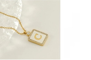 Macro shot of 18K gold plated square pendant featuring a shell C and micro-pave crystals