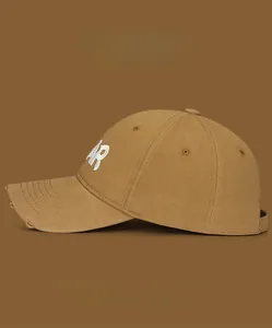 Close-up of khaki baseball cap with white AR embroidery and distressed brim detail