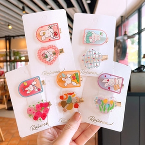 Macro detail of cute acrylic cartoon hair clips featuring rabbits and tulip patterns