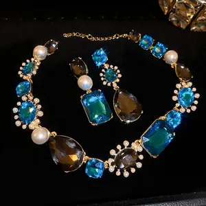 Luxurious vintage jewelry set with geometric blue crystals and pearl tassels on black silk