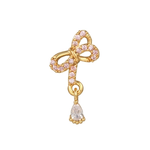 Detail of golden bow earring with pink micro-pave crystals and pear-shaped drop
