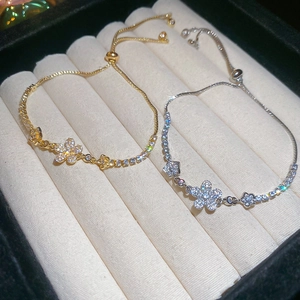 Macro detail of adjustable flower bracelets in gold and silver with zircon petals