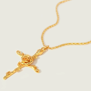 Detailed view of a gold cross pendant necklace with an intricate rose flower center