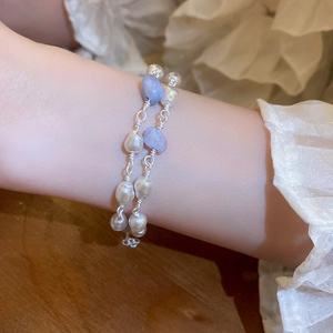 Close-up of double-layer bracelet with irregular freshwater pearls and blue gemstones