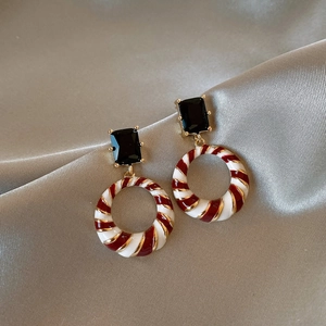 Detail of vintage geometric earrings with red and white enamel rings on champagne silk