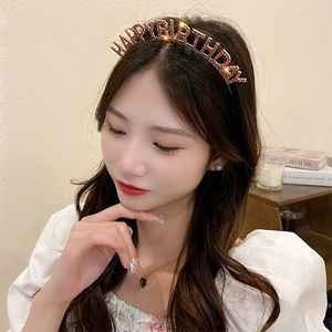 Elegant HAPPY BIRTHDAY rhinestone headband worn by a model in a warm indoor party setting