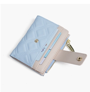 Detail of light blue quilted short wallet showing multi-color card slots and gold zipper