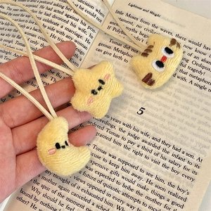 Close-up of cute plush star and moon charms on a soft fabric strap with detailed embroidery