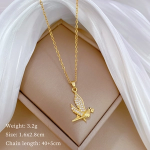 Macro detail of gold swallow necklace with pavé cubic zirconia on beige jewelry display