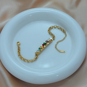 Rainbow cubic zirconia bracelet in gold finish displayed on silk and ceramic