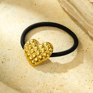Elastic black hair tie featuring a golden heart charm with a textured diamond pattern