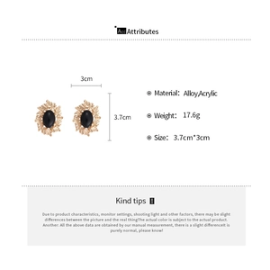 Detailed view of vintage gold-tone leaf earrings with black oval stones and dimensions