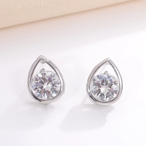 Detailed view of silver teardrop earrings with sparkling circular zircon gemstone setting