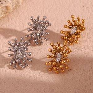 Detailed shot of gold and silver sunburst stud earrings with oval cubic zirconia stones