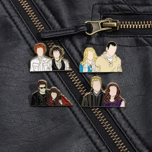 Detail of four Twilight character enamel pins pinned on a black leather biker jacket
