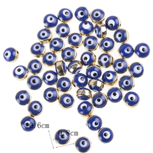 Flat lay of 6mm and 8mm blue evil eye resin beads with gold metal edges for DIY jewelry