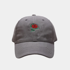 Close-up of red rose embroidery on a grey cotton baseball cap with high detail texture