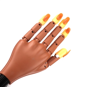 Detailed close-up of a brown flexible nail practice hand model with colored fake nail tips